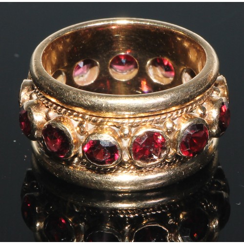 108 - A 14ct gold eternity ring, set with a band of colette set facet cut garnets, within ripe twist and r... 