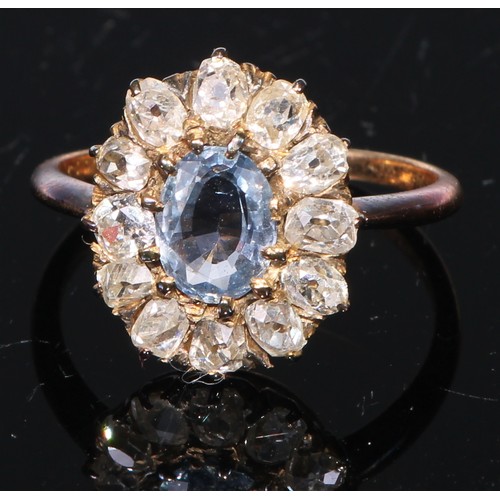 267 - An early 20th century diamond and blue topaz cluster, the central oval stone within 12 diamonds, gol... 