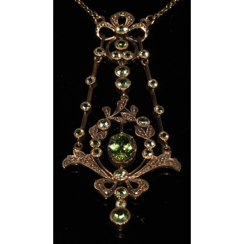 256 - An Edwardian peridot floral ribbon bow pendant necklace, vibrant oval principle stone, twenty four s... 