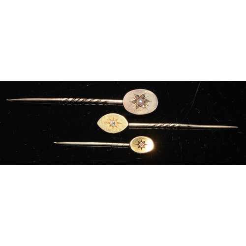 122 - A 19th century diamond and seed pearl yellow metal stick pin, as a flower, unmarked;  another navett... 