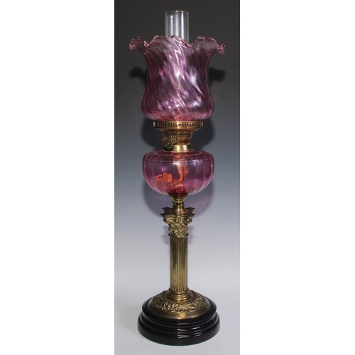 441 - A Victorian brass Corinthian column oil lamp, cranberry glass shaped and reservoir, 62cm high, c.190... 