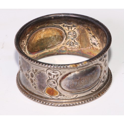 12 - A George V silver triangular napkin ring, engine turned, Birmingham 1920; eight other silver napkin ... 