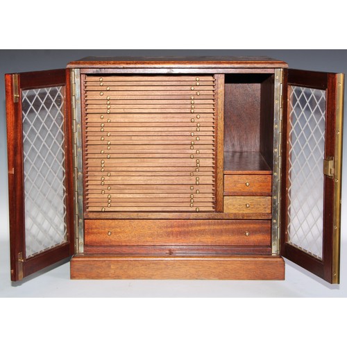 273 - A mahogany table top coin collector's cabinet, the faux-leaded glazed doors enclosing sliding trays ... 