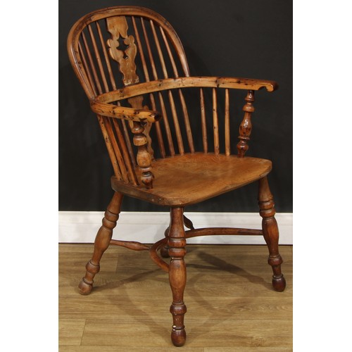 102 - A 19th century Yorkshire yew and elm Windsor elbow chair, hoop back, shaped and pierced Christmas tr... 