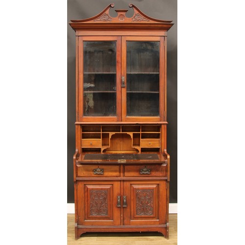 105 - An Art Nouveau period walnut secretaire bookcase, swan neck pediment above a pair of glazed doors en... 