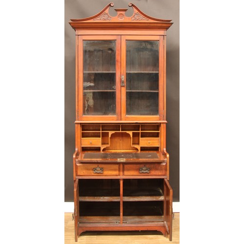 105 - An Art Nouveau period walnut secretaire bookcase, swan neck pediment above a pair of glazed doors en... 