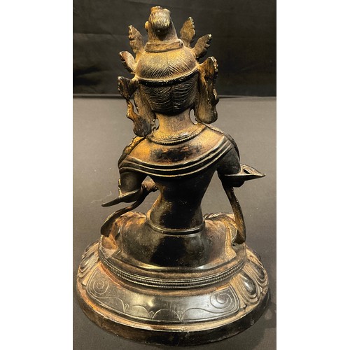 87 - A bronzed metal figure as a seated goddess, possibly Tibetan, 20cm high, 20th century