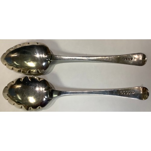 364 - A composed pair of silver GIII Old English pattern berry spoons, engraved and chased with foliate sc... 