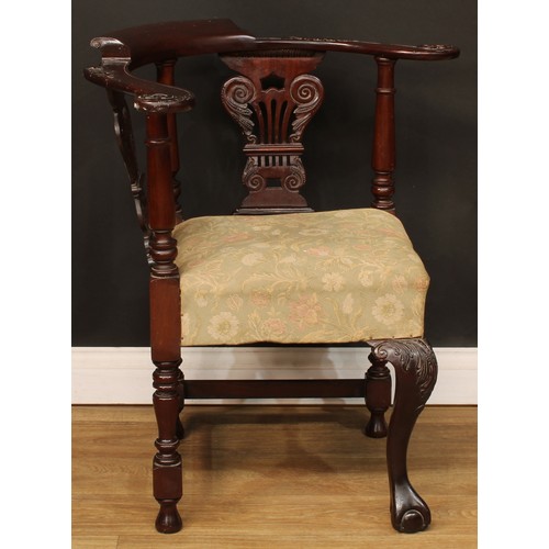 116 - A George II Revival mahogany corner chair, curved cresting rail, the arms carved with scrolling acan... 