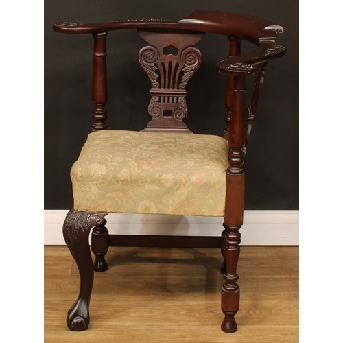 116 - A George II Revival mahogany corner chair, curved cresting rail, the arms carved with scrolling acan... 