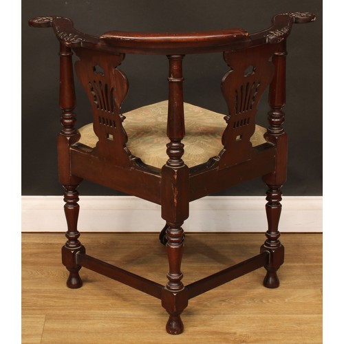 116 - A George II Revival mahogany corner chair, curved cresting rail, the arms carved with scrolling acan... 