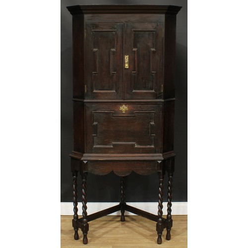 114A - An unusual Jacobean Revival oak secretaire cabinet on stand, for the corner, 183cm high, 86cm wide, ... 