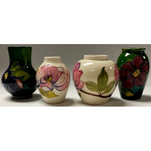 18 - A Moorcroft Clematis pattern miniature ovoid vase, 11cm, another similar, 11cm; two Moorcroft Magnol... 