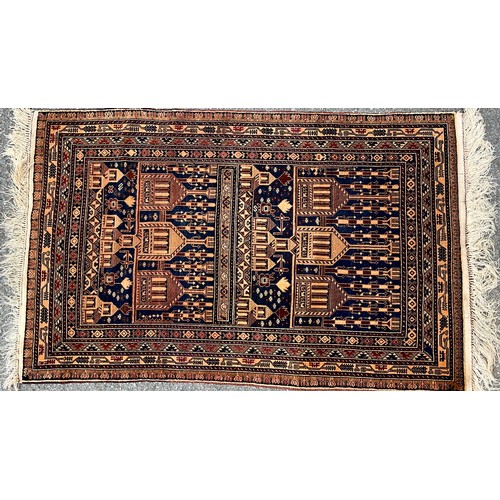 466 - A woollen rug, decorated with temples, in shades of brown and blue, 150cm x 92cm