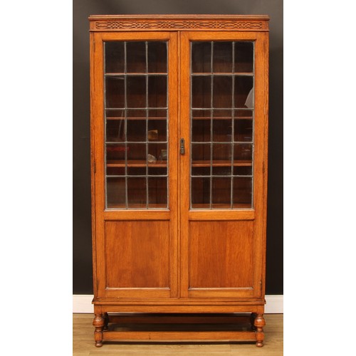 207 - An early 20th century oak lead glazed library bookcase, blind fretwork frieze, 183cm high, 96cm wide... 