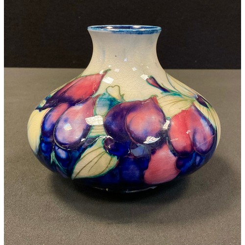 41 - A Moorcroft Wisteria pattern compressed ovoid vase, tube lined with foliage, in tones of purple, yel... 