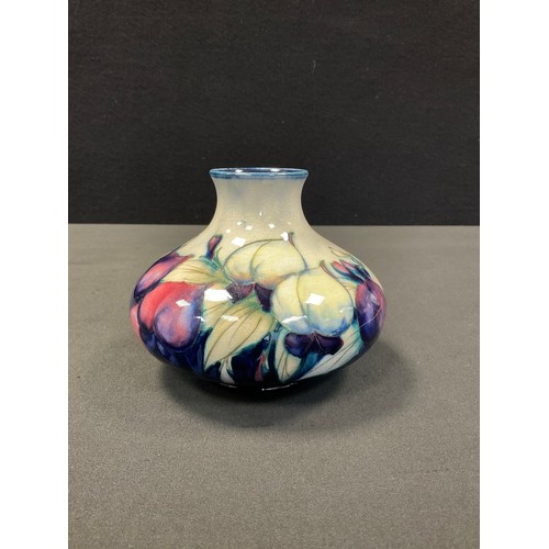 41 - A Moorcroft Wisteria pattern compressed ovoid vase, tube lined with foliage, in tones of purple, yel... 