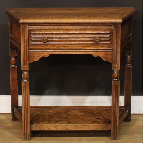 584 - An oak canted side table, oversailing top above a long frieze drawer, open undertier, 72.5cm high, 8... 