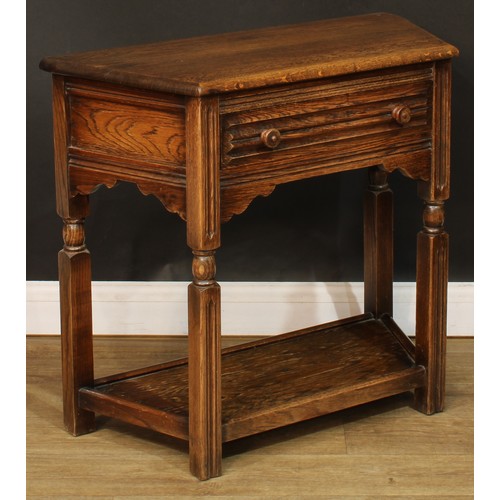 584 - An oak canted side table, oversailing top above a long frieze drawer, open undertier, 72.5cm high, 8... 