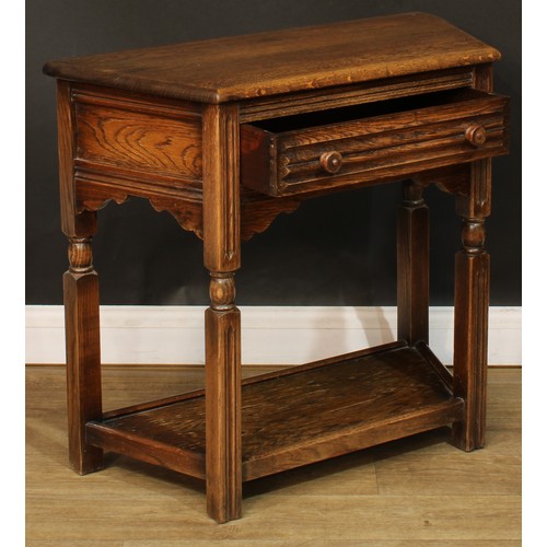 584 - An oak canted side table, oversailing top above a long frieze drawer, open undertier, 72.5cm high, 8... 