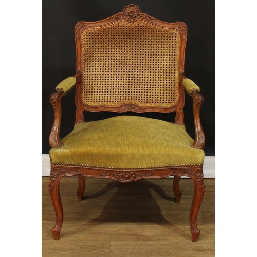 106 - A Louis XV design fauteuil or open armchair, shaped cresting carved with trailing flowering stems an... 