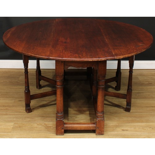 594 - An oak double gateleg table, oval top with fall leaves, 73cm high, 164.5cm long, 52cm opening to 143... 