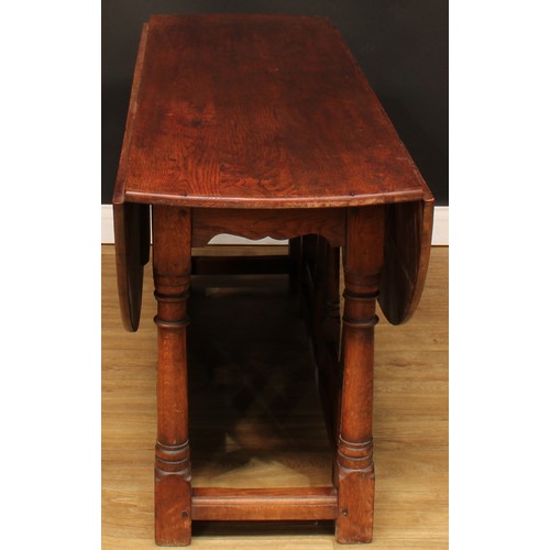 594 - An oak double gateleg table, oval top with fall leaves, 73cm high, 164.5cm long, 52cm opening to 143... 