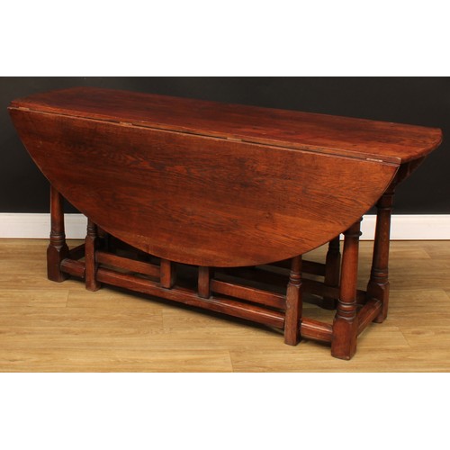 594 - An oak double gateleg table, oval top with fall leaves, 73cm high, 164.5cm long, 52cm opening to 143... 