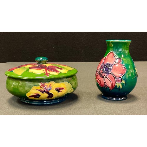 48 - A Moorcroft Hibiscus pattern trinket pot and cover, tube lined with large flowerheads in tones of re... 