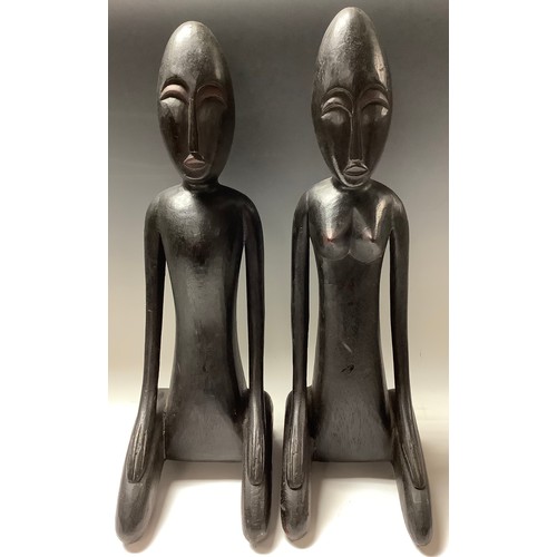 620 - African Art - a pair of ebonised stylised figrues, kneeling, 51cm high