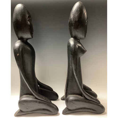 620 - African Art - a pair of ebonised stylised figrues, kneeling, 51cm high