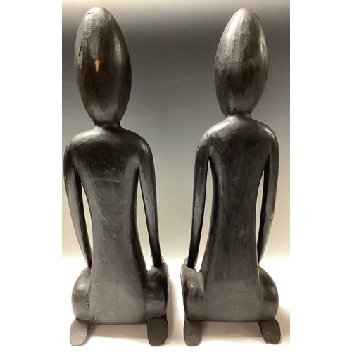 620 - African Art - a pair of ebonised stylised figrues, kneeling, 51cm high