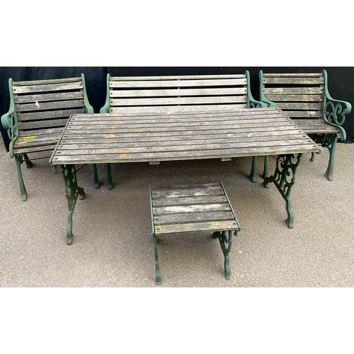 3027 - A heavy cast iron and wooden slatted garden table, bench, two chairs and stool, 155cm wide, 68.5cm d... 