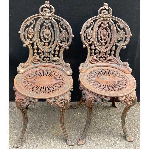 3011 - A pair of 19th century heavy cast iron garden chairs, in the manner of Coalbrookdale, and a conformi... 