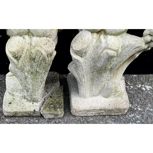 3059 - A pair of reconstituted garden statues, of young boys, one holding grapes,  the other a scythe, 69cm... 