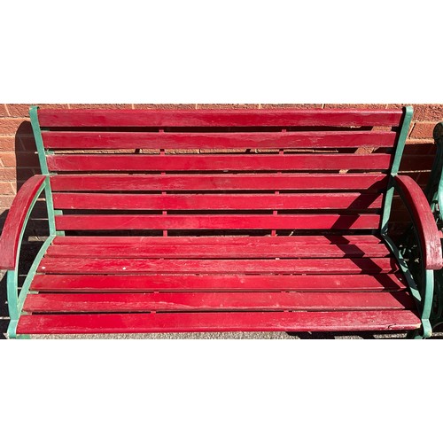 3125 - Two cast iron and wooden slatted garden benches, now painted in green and red, the sides pierced len... 