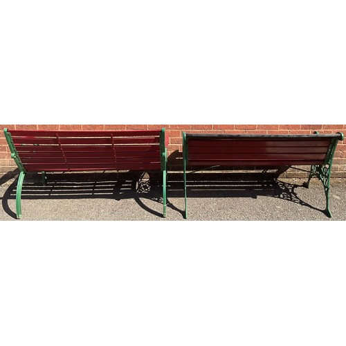 3125 - Two cast iron and wooden slatted garden benches, now painted in green and red, the sides pierced len... 