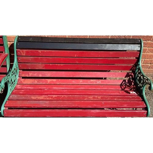 3125 - Two cast iron and wooden slatted garden benches, now painted in green and red, the sides pierced len... 