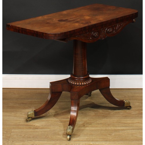 1776 - A Regency rosewood tea table, hinged top above a deep frieze carved with scrolling lotus and bosses,... 