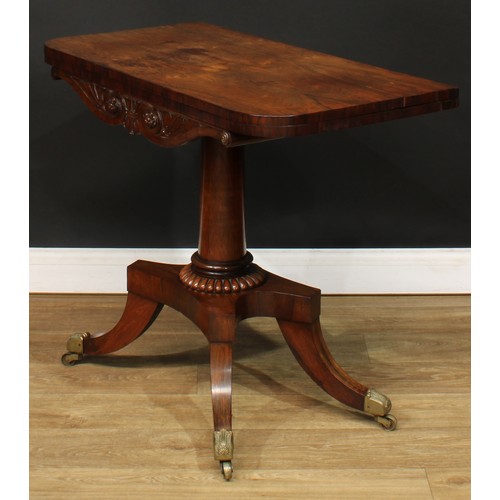 1776 - A Regency rosewood tea table, hinged top above a deep frieze carved with scrolling lotus and bosses,... 