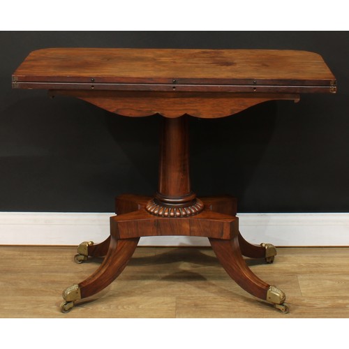 1776 - A Regency rosewood tea table, hinged top above a deep frieze carved with scrolling lotus and bosses,... 