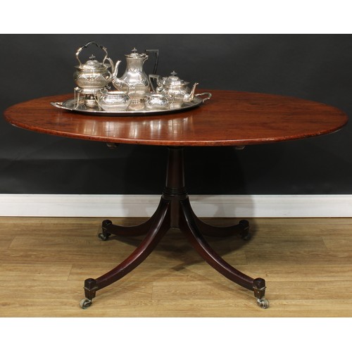 1761 - A Regency mahogany centre table, oval tilting top, turned column, sabre legs, brass casters, 71cm hi... 