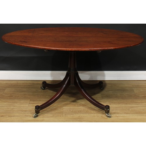 1761 - A Regency mahogany centre table, oval tilting top, turned column, sabre legs, brass casters, 71cm hi... 