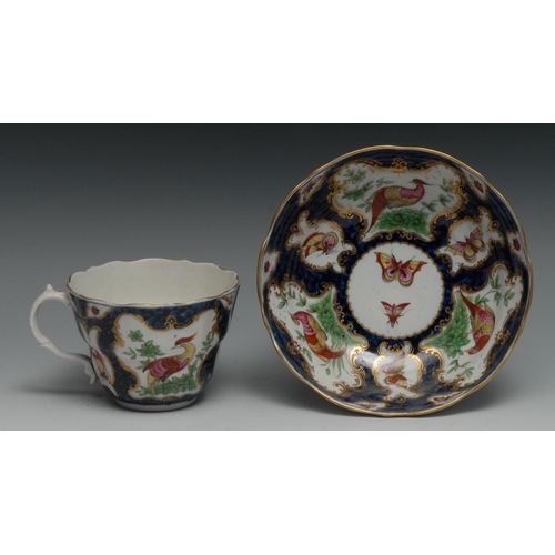 672 - A Worcester Trembluese  cup and saucer, painted in the manner of Giles with fanciful birds on a scal... 