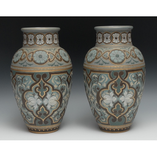 516 - A pair of  Doulton Lambeth Silicon vases, incised with and in relief with flowers, and scrolls, in b... 