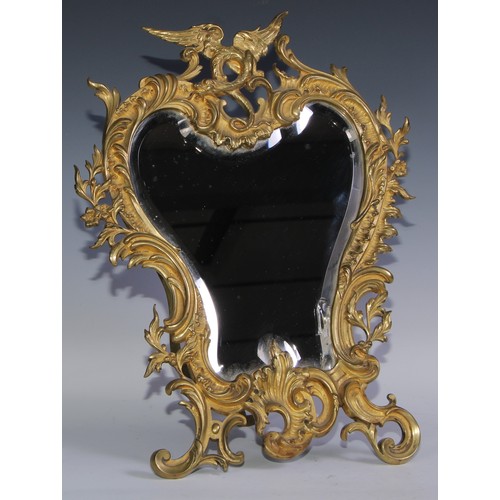 1626 - A 19th century Rococo Revival gilt metal cartouche shaped easel table mirror, bevelled plate, the fr... 