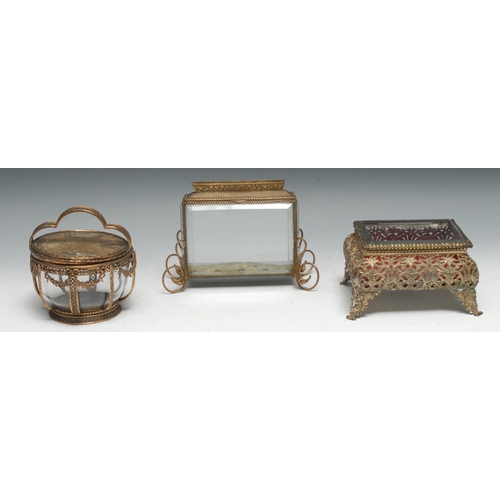 1269 - A French gilt metal circular dressing table box,  shaped handle, the glazed lid set with lace and si... 