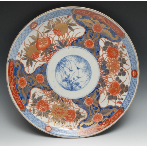 999 - A Japanese Imari charger, painted with flowers, picked out in gilt, central blue and white panel pai... 