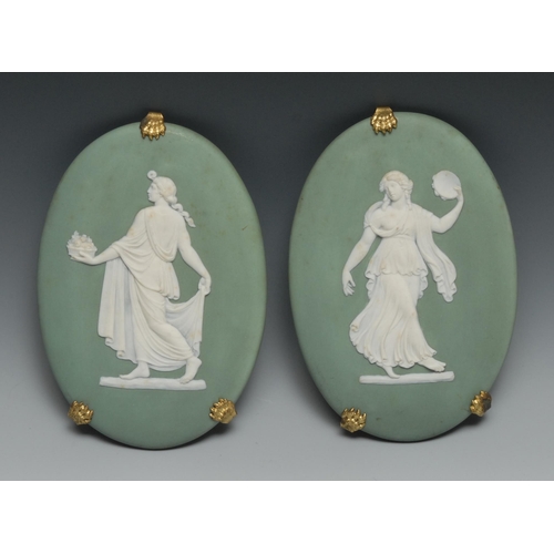 552 - A pair of 19th century Wedgwood Jasperware oval plaque, typically sprigged in white with classical f... 