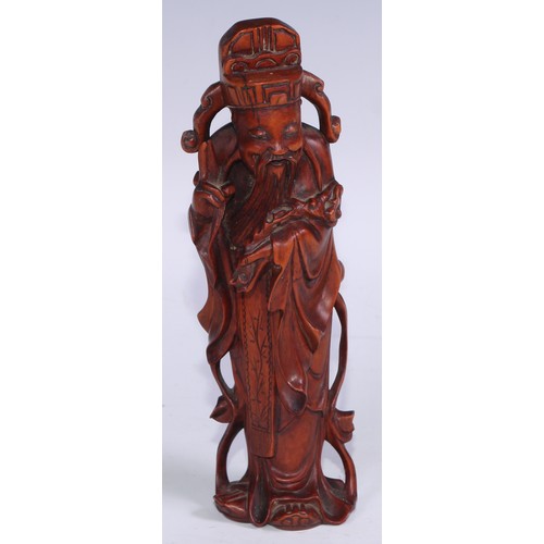 905 - A Chinese boxwood figure, carved as an Immortal, he stands, holding a ruyi sceptre, 21cm high, 19th/... 